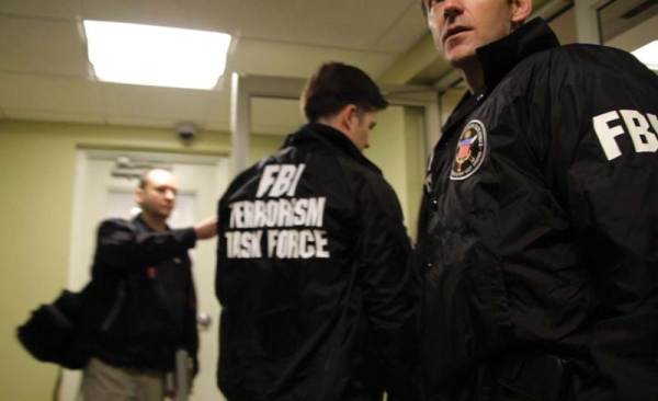 Agents in FBI jackets in hallway. Still from "(T)error". 2016. This image is not available under the 4.0 Creative Commons license.