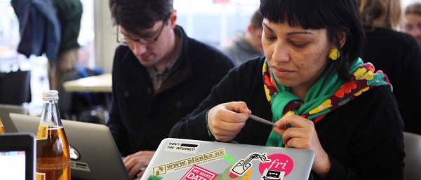 A participant puts stickers on her laptop at the 28th Chaos Communication Congress in Berlin. Credit: Adam Berry / Stringer