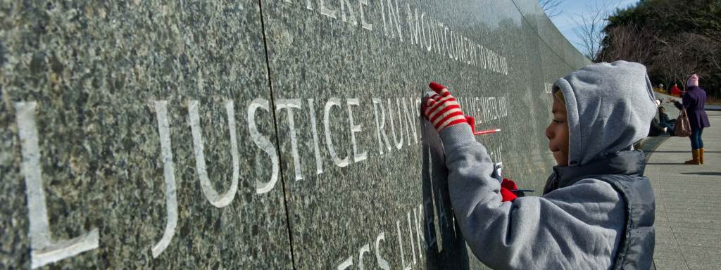 Boy in front of "The Civil Rights Memorial Center" wall in Montgomery, Alabama.