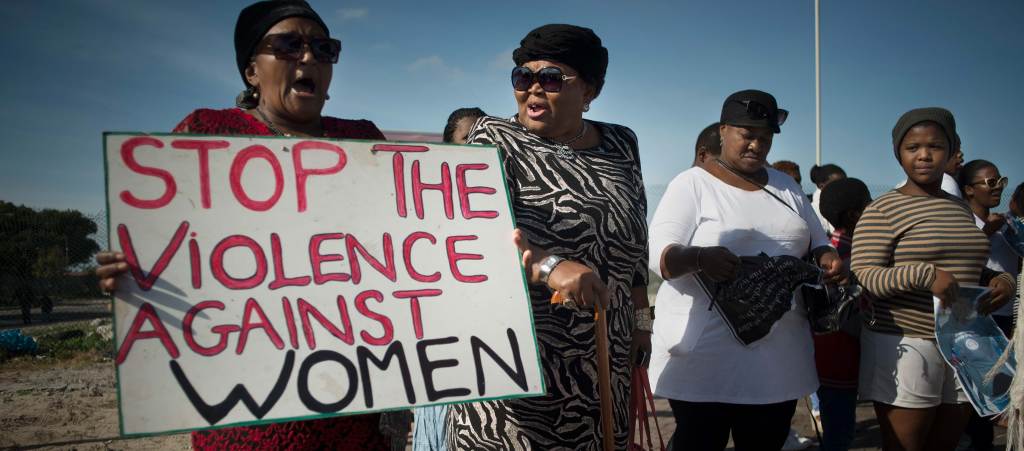 Women hold signs during a protest against violence against women, in Gugulethu.