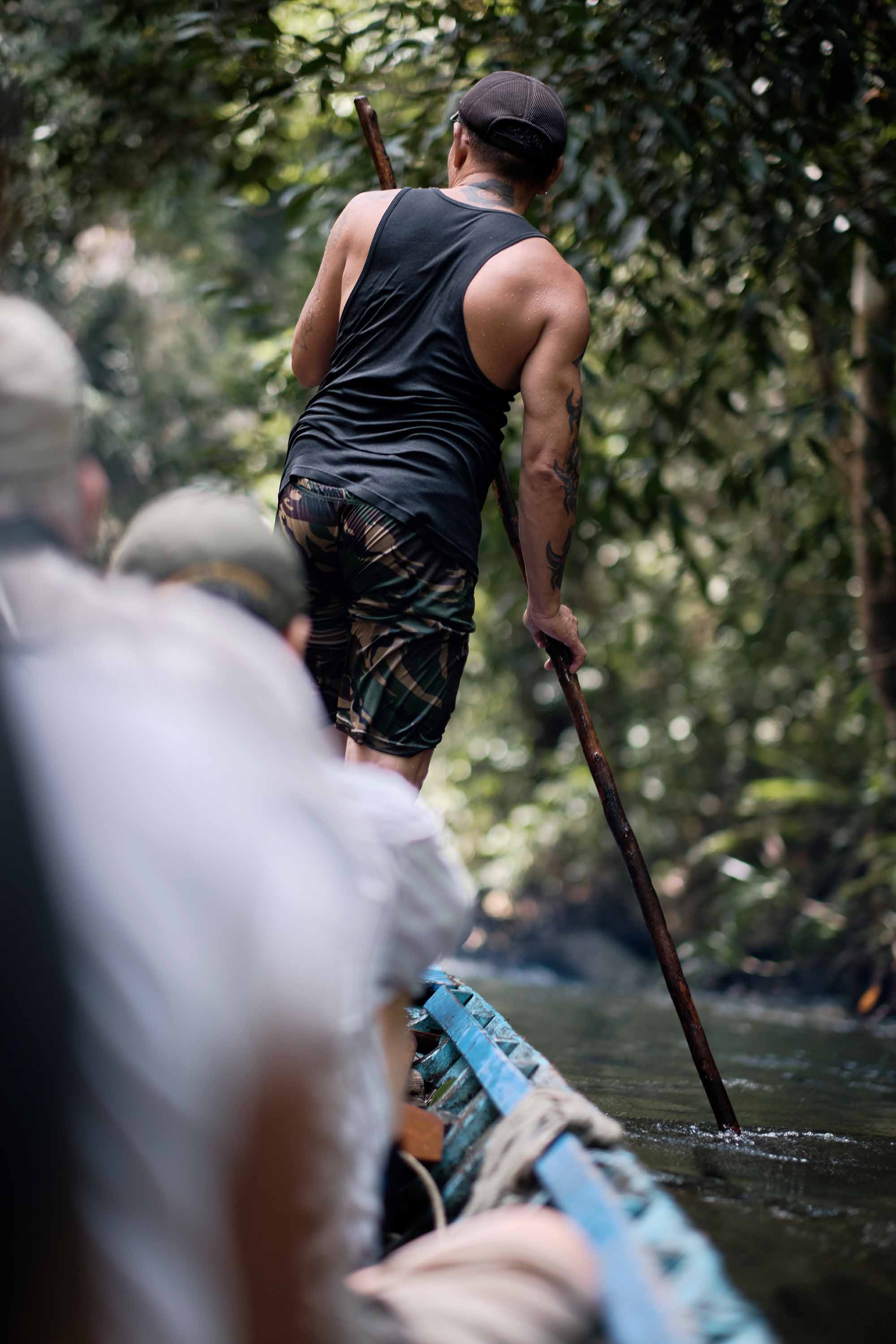 A man touches the river bed with a long stick to guide the canoe as he leads a tour of the Sungai Utik forest.