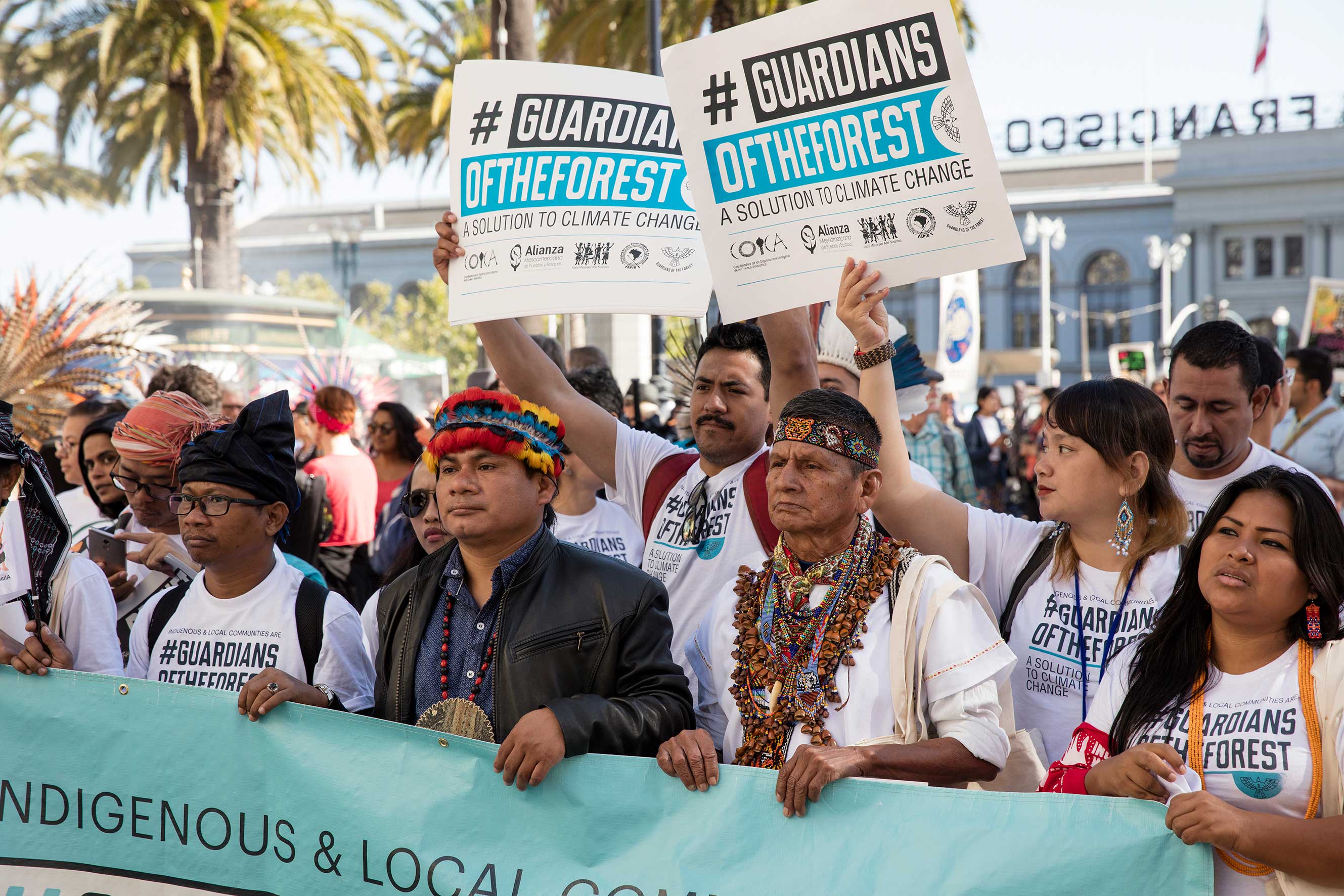 A group of indigenous leaders holds a large sign with the text Guardians of the forest during the 2018 Global Climate Action Summit  march in San Francisco. 