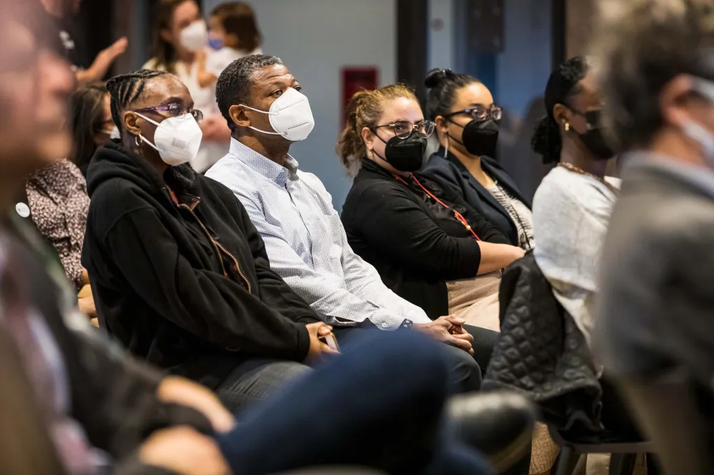People wearing n95 masks sitting in an audience.