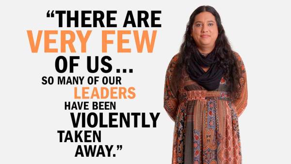 Isa Noyola has long dark curly hair and is wearing a brown patterned dress and black scarf. She's standing next to copy that reads, "There are very few of us... so many of our leaders have been violently taken away."