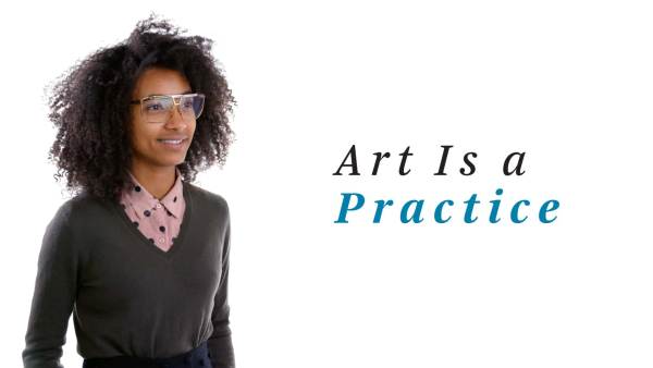 Esperanza Spalding, a black woman, is wearing a charcoal gray v-neck sweater over a pink button-down blouse with black polka dots. The phrase "Art Is Practice" appears to her right.