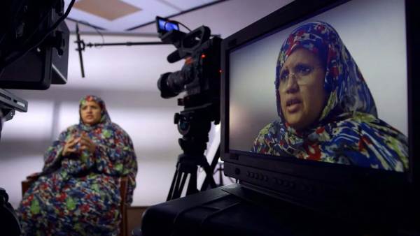 Fatimetou Abdel Malick sits in front a camera with her face showing on the monitor.