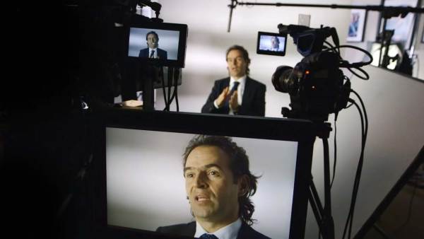 Federico Gutiérrez Zuluaga sitting on a film set in front of multiple cameras with his face displayed on all monitors. 