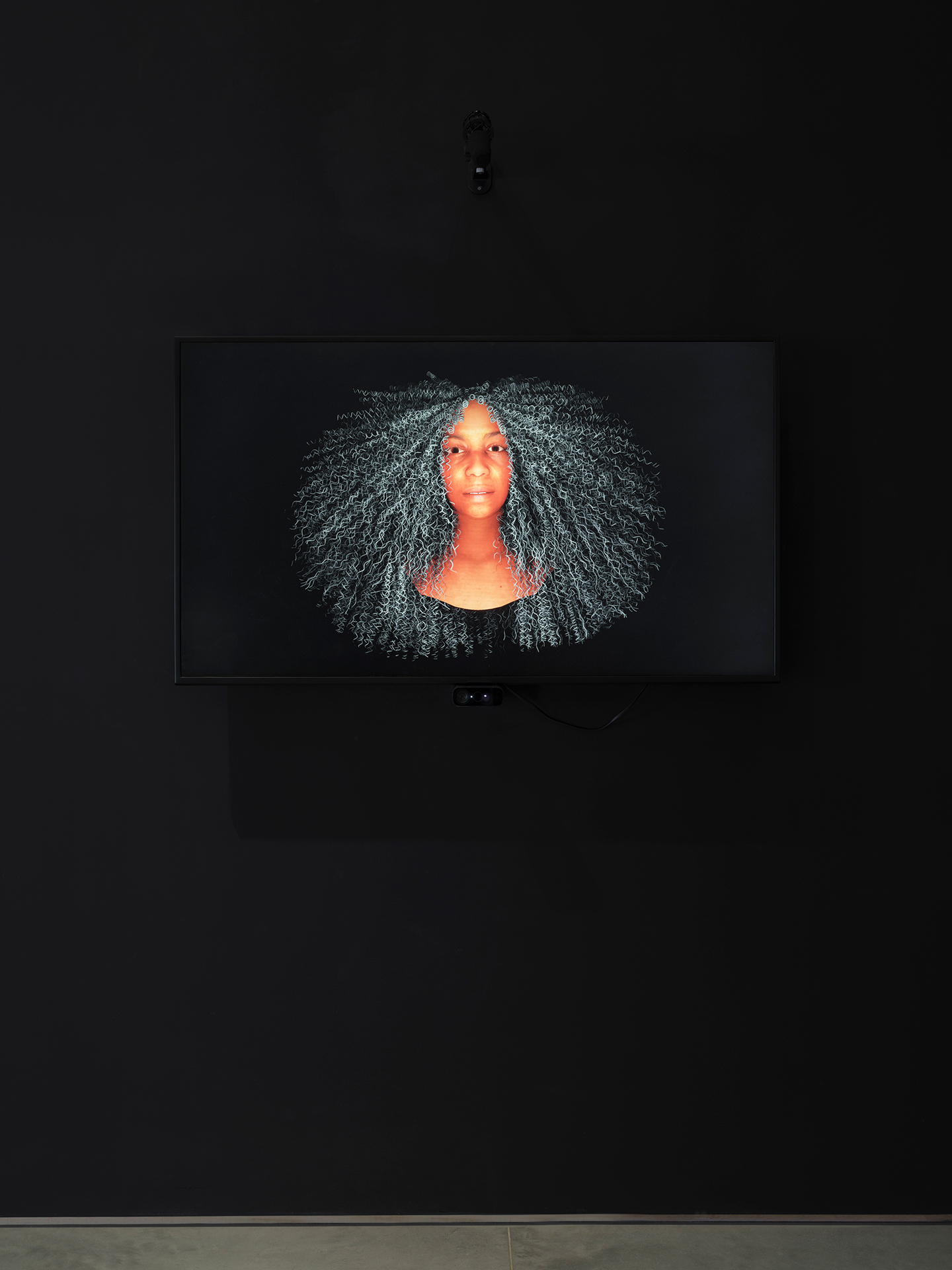 Image of a Black woman’s head on a black background. The woman has saturated orange skin and long white curly hair.